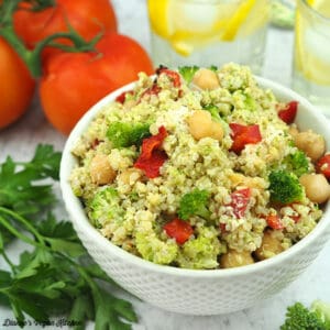 small bowl of quinoa salad with lemon water and tomatoes