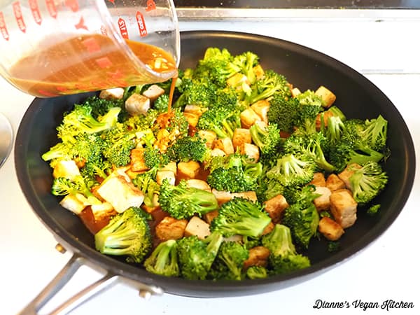 pouring teriyaki sauce for tofu and broccoli 