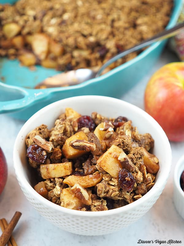 bowl of apple crisp with baking dish in background