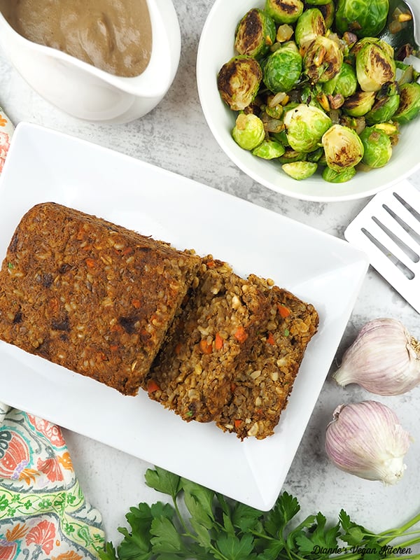 sliced lentil loaf overhead with brussels sprouts and gravy
