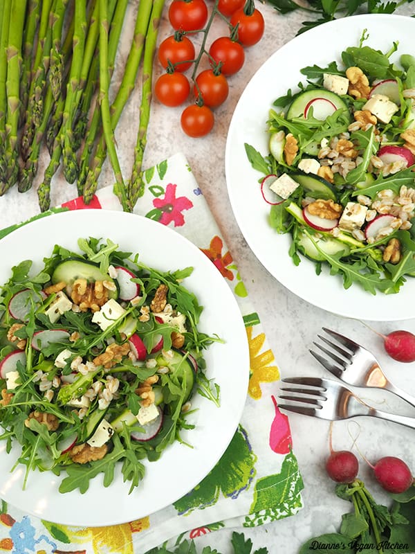 two bowls of salad with asparagus, tomatoes, and radishes