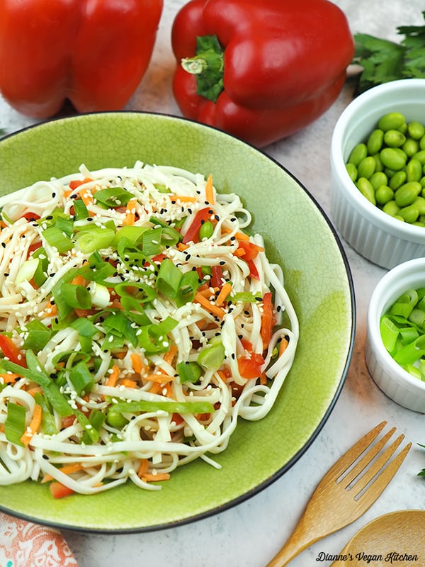 bowl of noodles with edamame, peppers and scallions