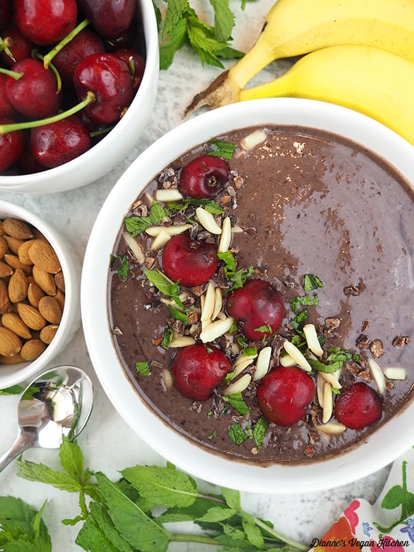 smoothie bowl with bananas, cherries, mint, and almonds
