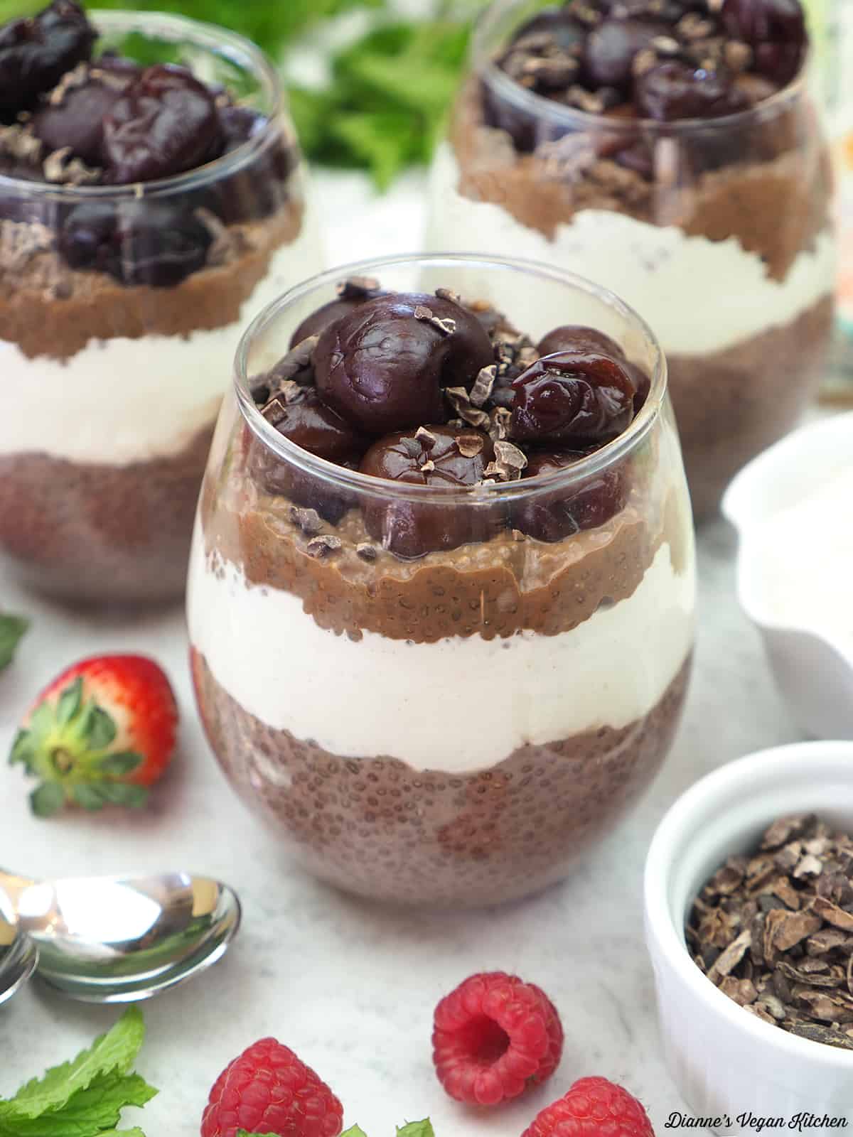 chia pudding cups with cashew cream, mint, strawberries, raspberries, and cacao nibs