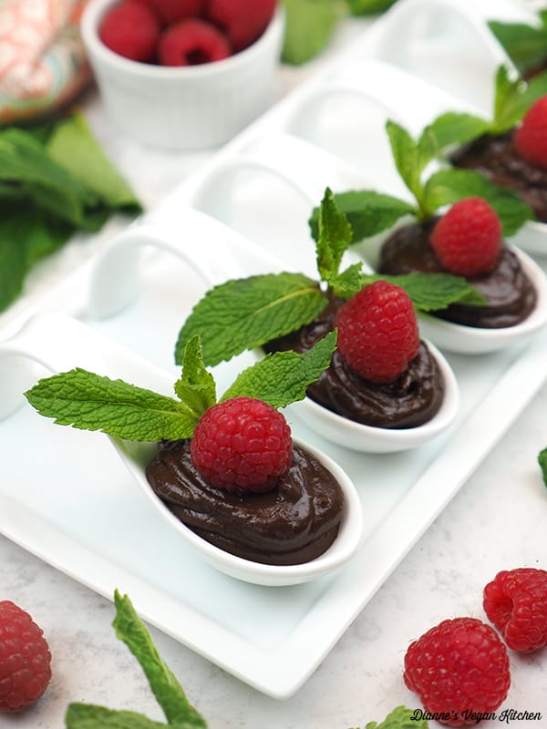 avocado chocolate mousse in spoons with raspberries and mint