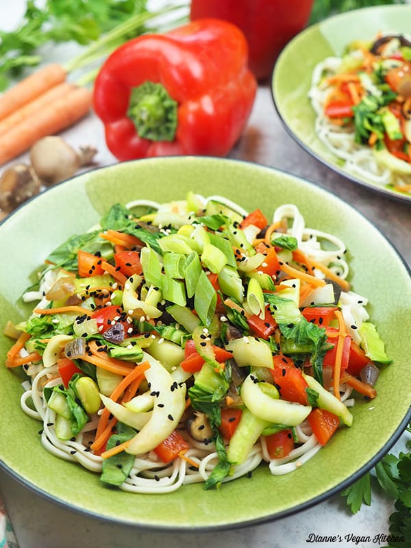 two bowls of stir-fry with carrots and peppers