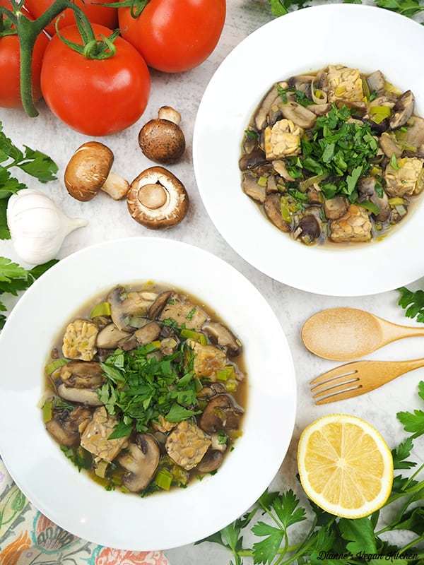 two bowls of vegan fricassee with mushrooms, lemon, garlic, and tomatoes