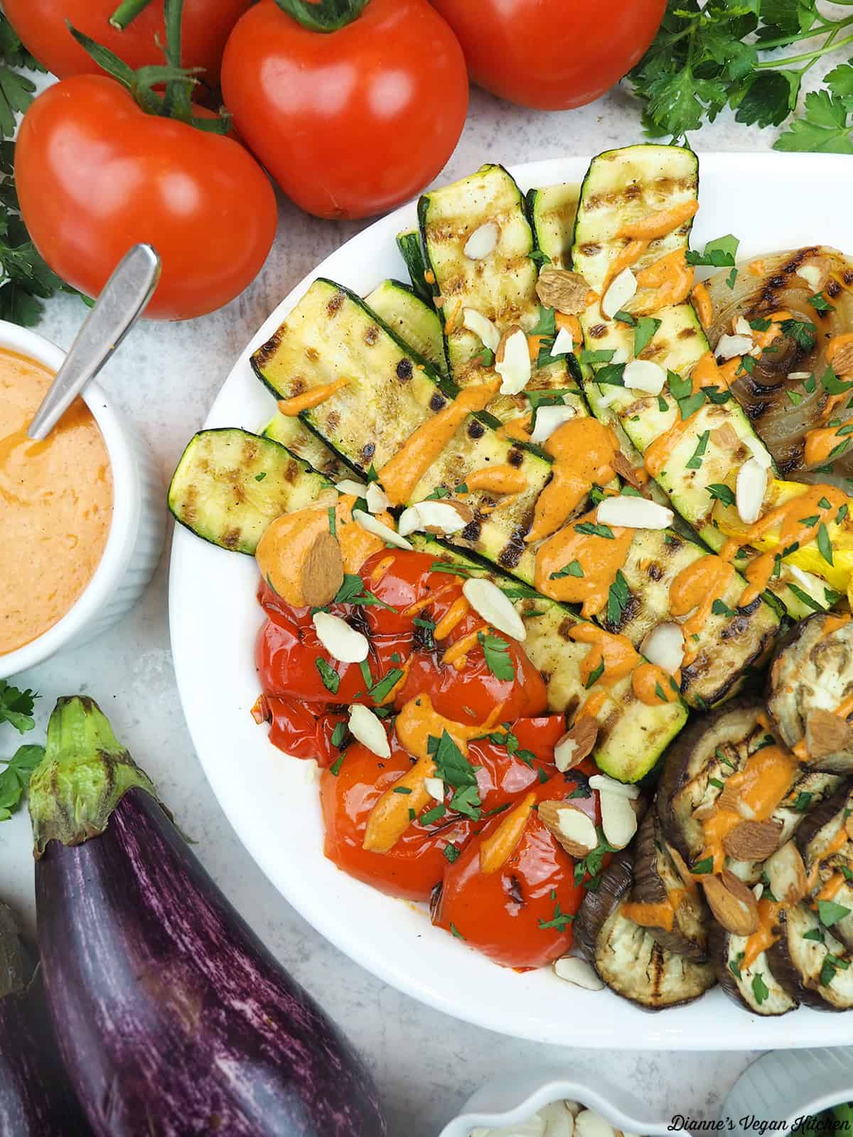 platter of grilled vegetables with tomatoes, eggplant, and romesco