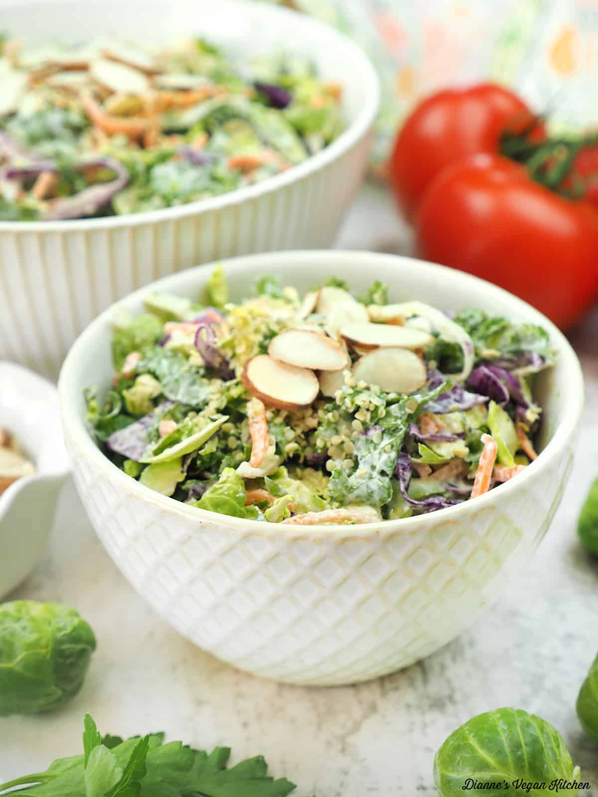 two bowls of salad with tomatoes and brussels sprouts