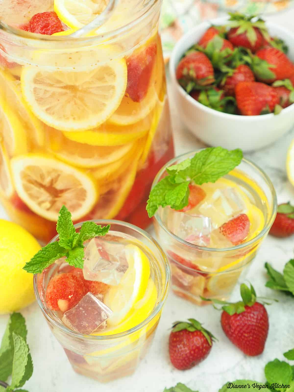 two glasses of white wine sangria with strawberries and lemon 