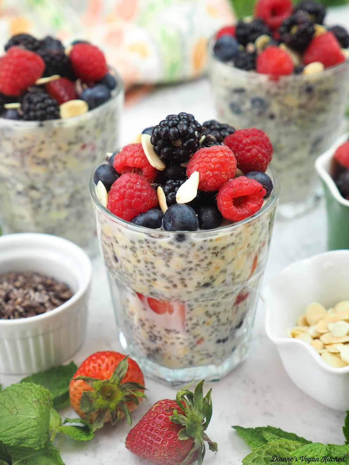 overnight oats with strawberries, mint leaves, slivered almonds, and cacao nibs