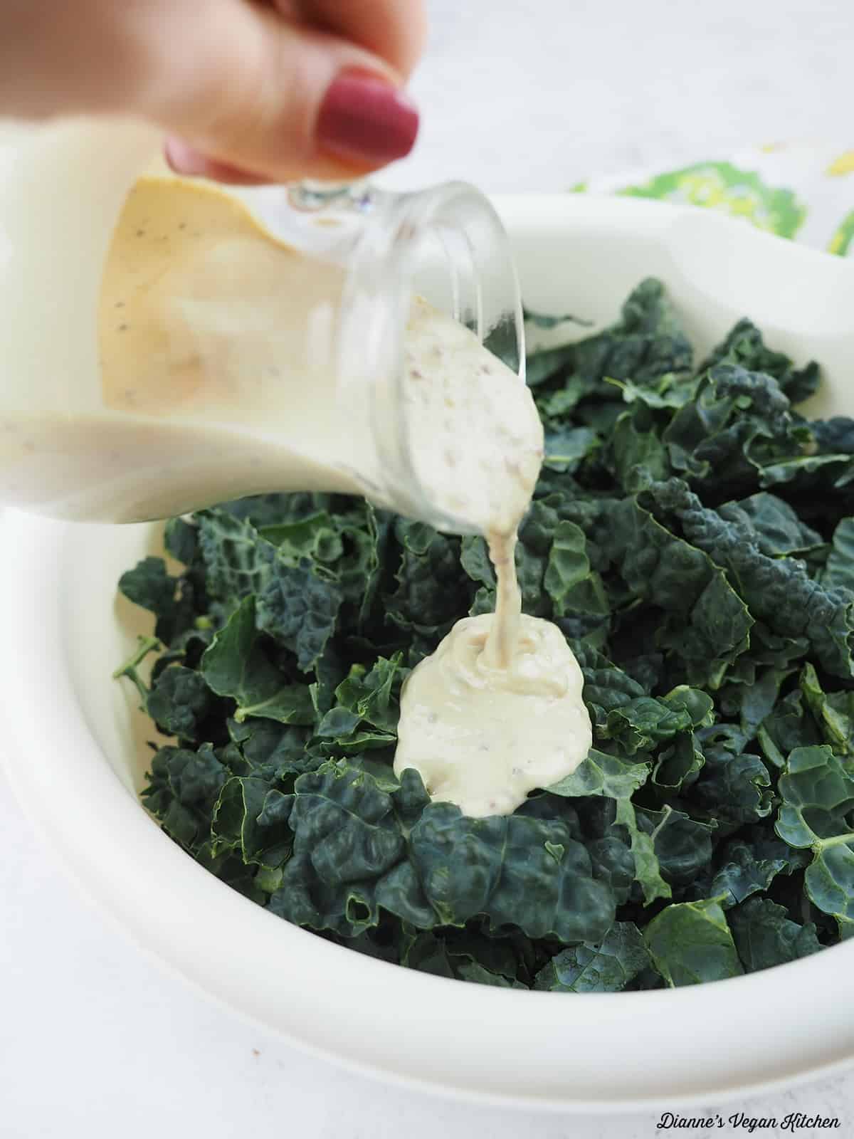pouring dressing on kale