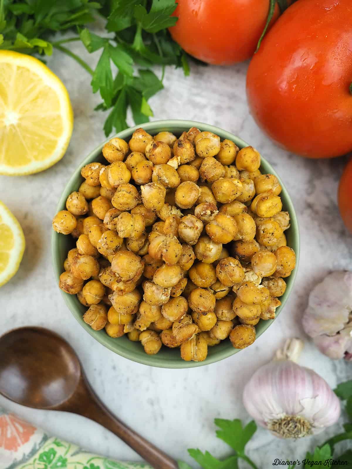 bowl of roasted chickpeas overhead with tomato, lemon, and garlic