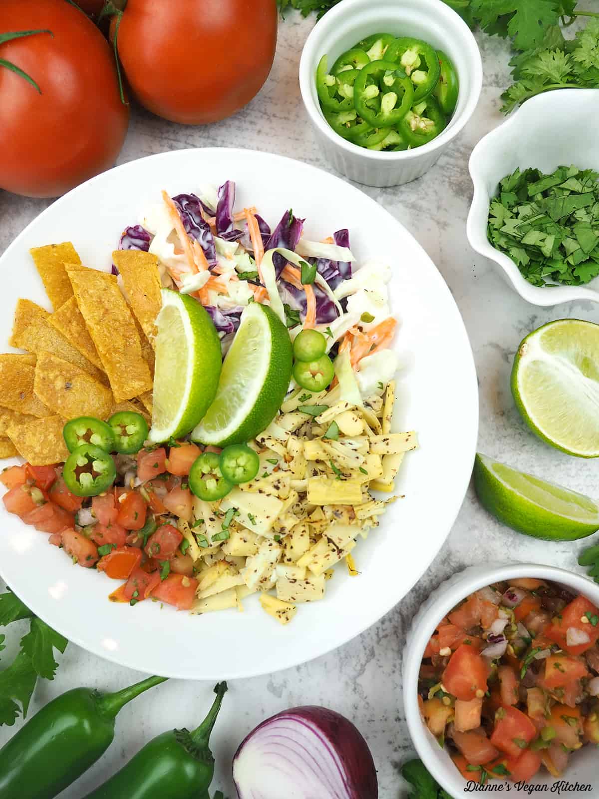 vegan fish taco bowl with tomatoes, cilantro, jalapeno, lime, pico de gallo, and onion