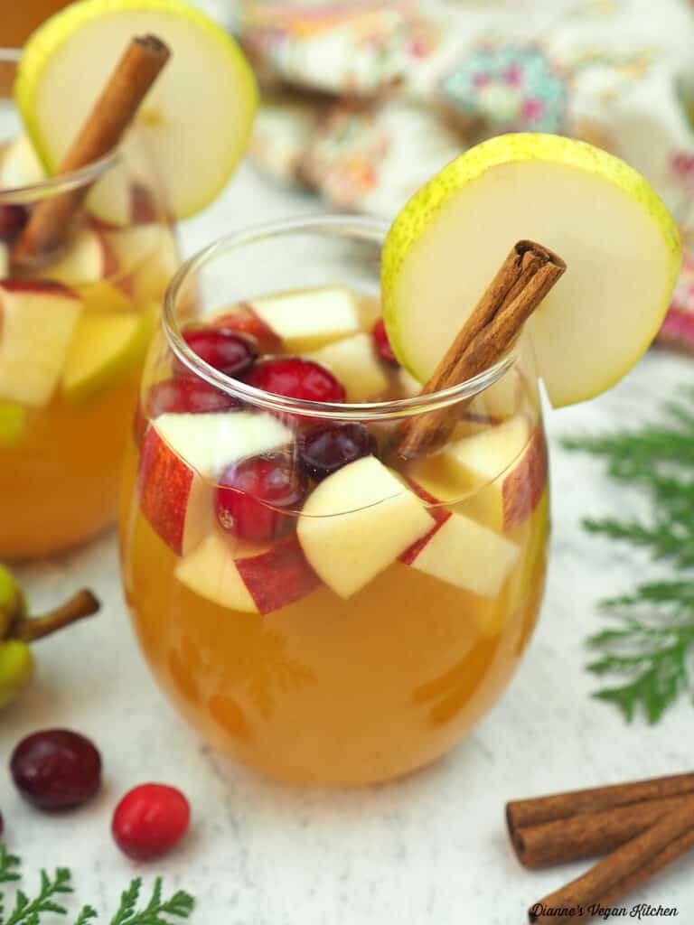 glass of sangria with cinnamon sticks and cranberries