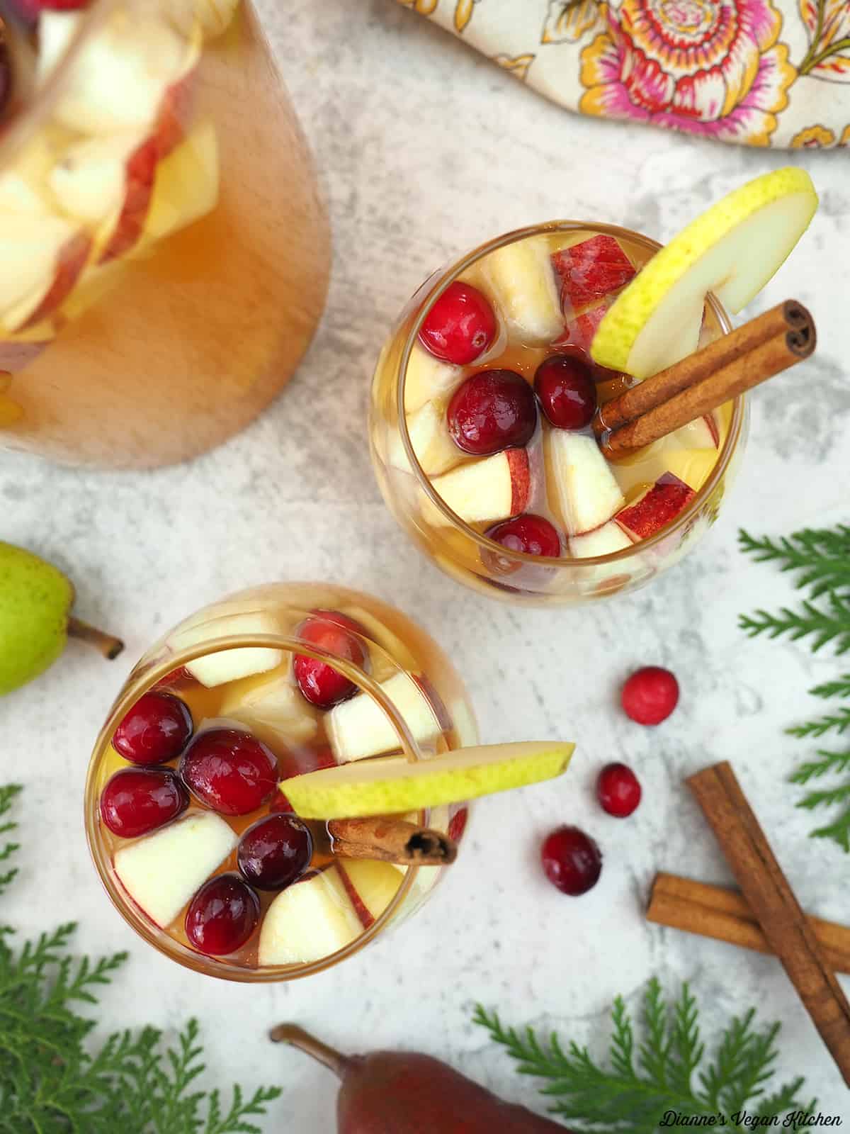 two glasses of sangria with cinnamon sticks and pears overhead