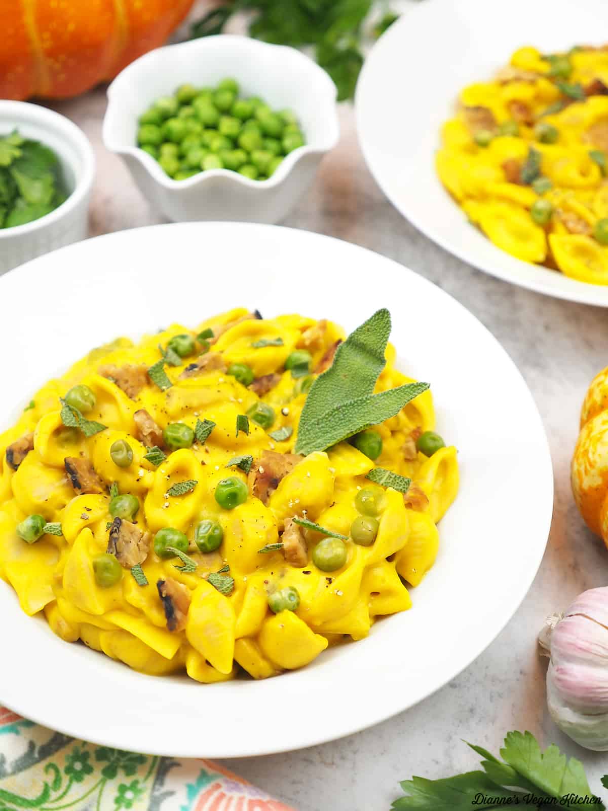 close up of bowl of pasta with peas, parsley, pumpkins and garlic