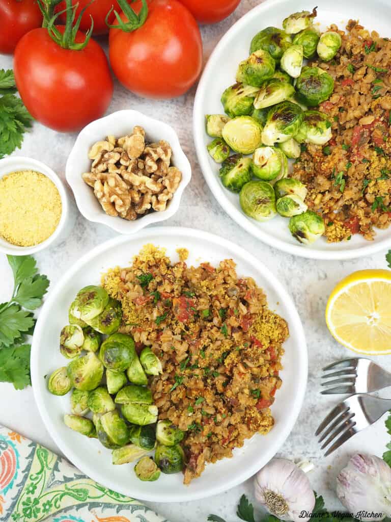 two plates of baked farro with brussels sprouts. tomatoes, walnuts, and lemon