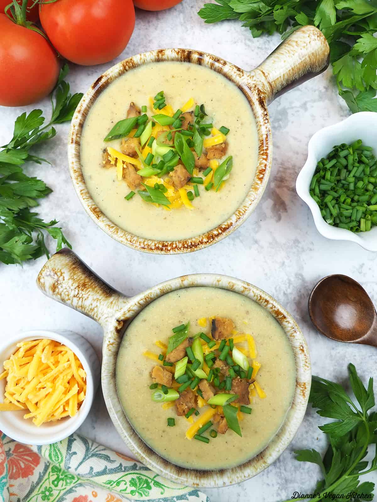 two crocks with soup with vegan cheddar and chives