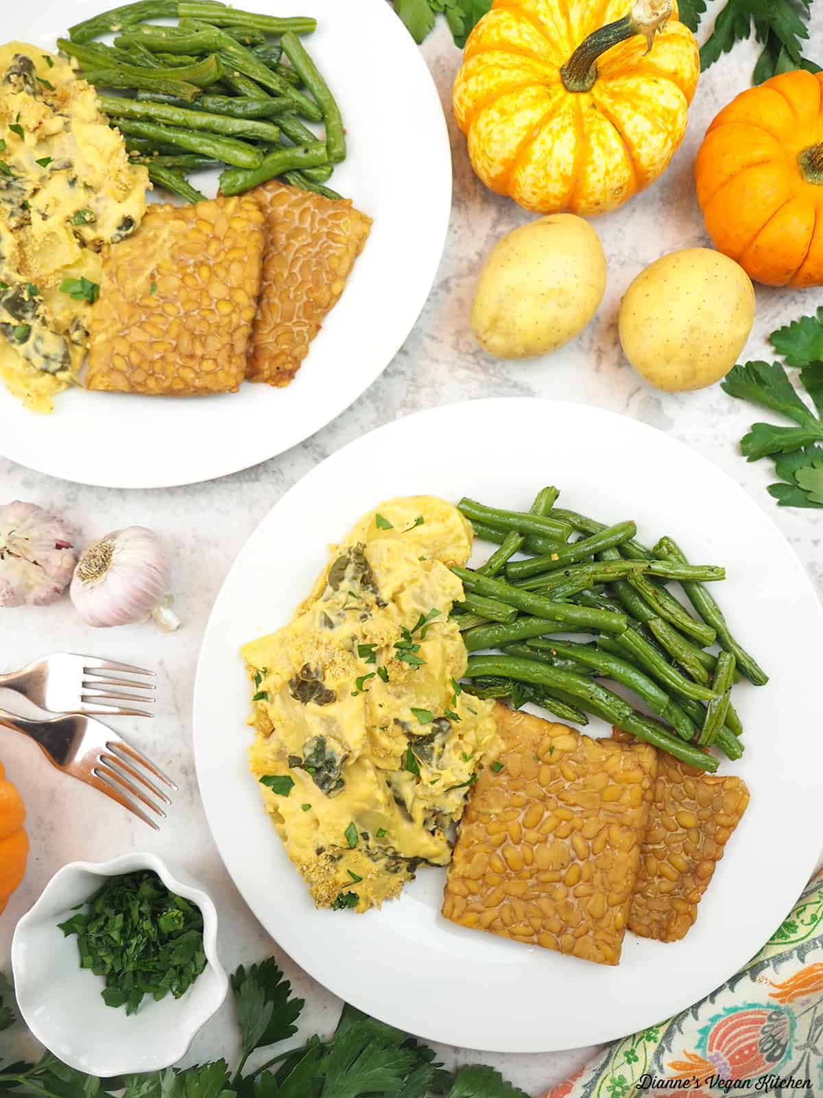 plates of potatoes, green beans, and roasted tempeh