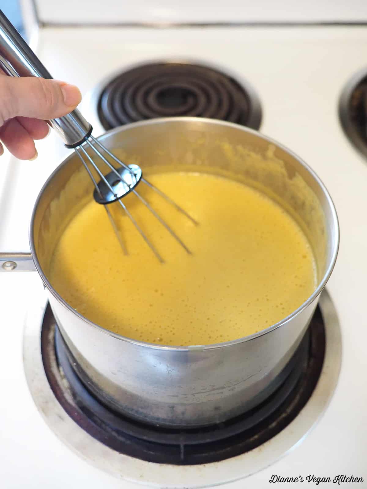 stirring cheese sauce in pot on stove