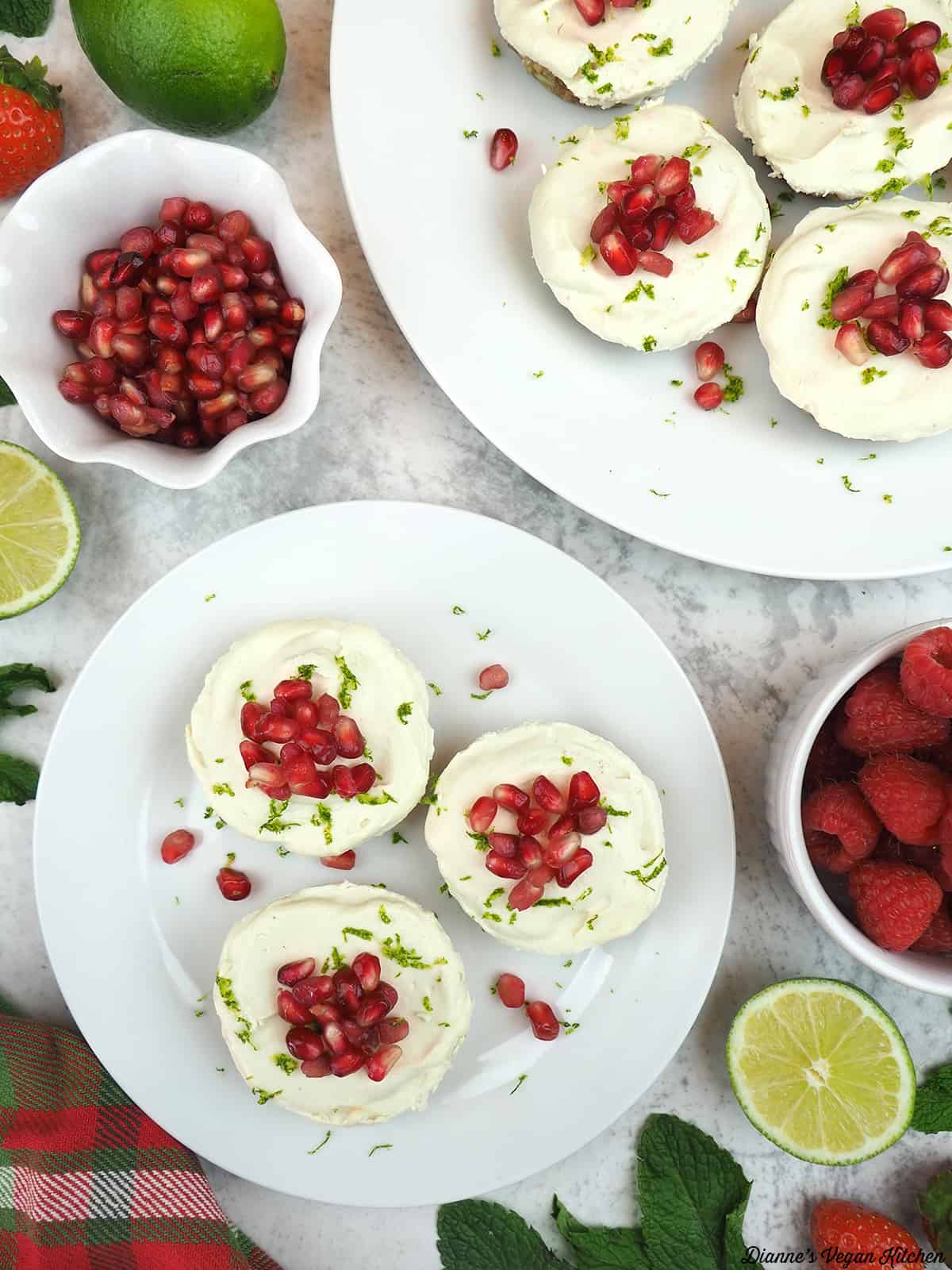 overhead of Vegan Key Lime Cheesecake with limes, berries, and pomegranate seeds