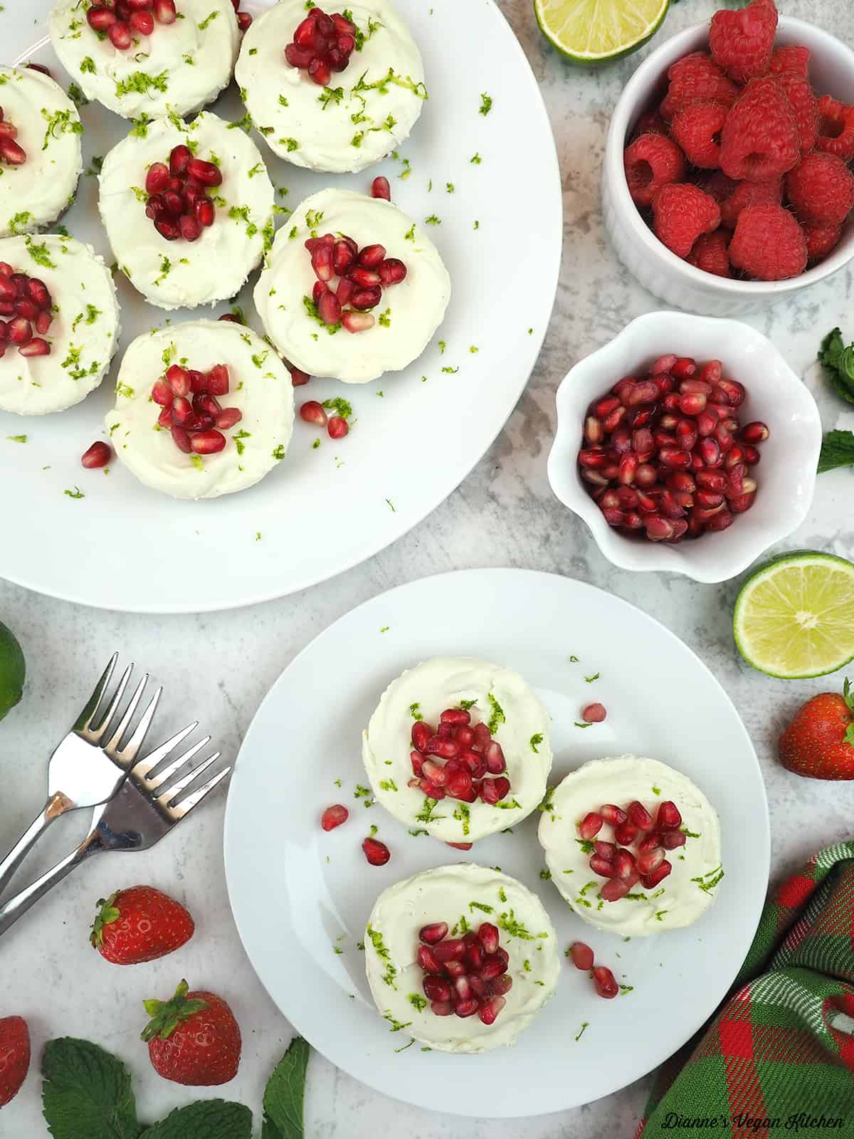 Vegan Key Lime Cheesecake with berries, limes, pomegranate seeds and forks