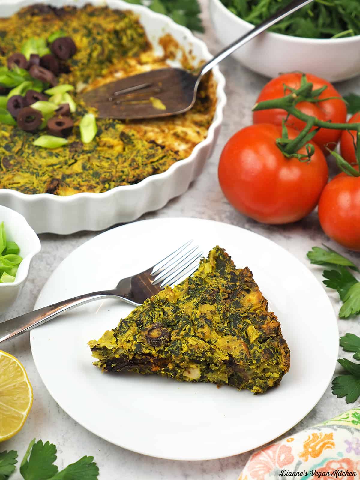 slice of frittata on plate with baking dish in background