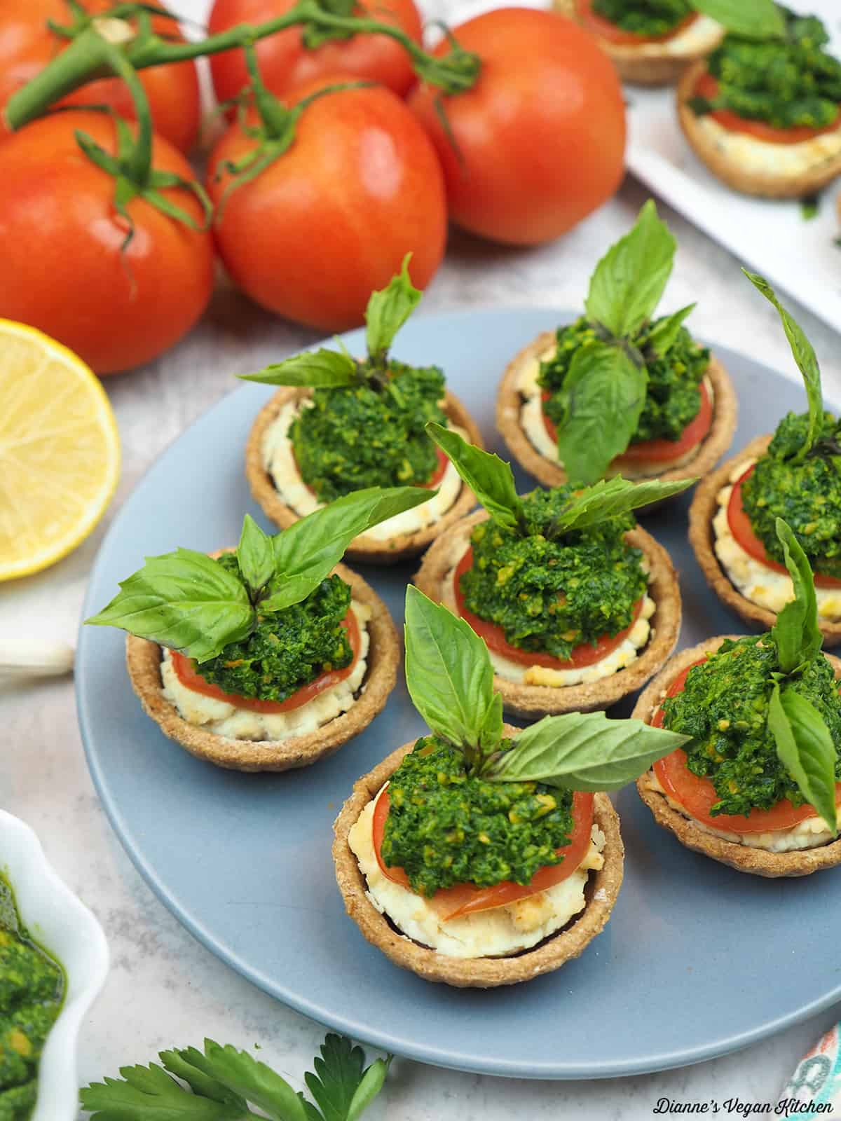 Plate with tomato tartlets with lemon, pesto and tomatoes