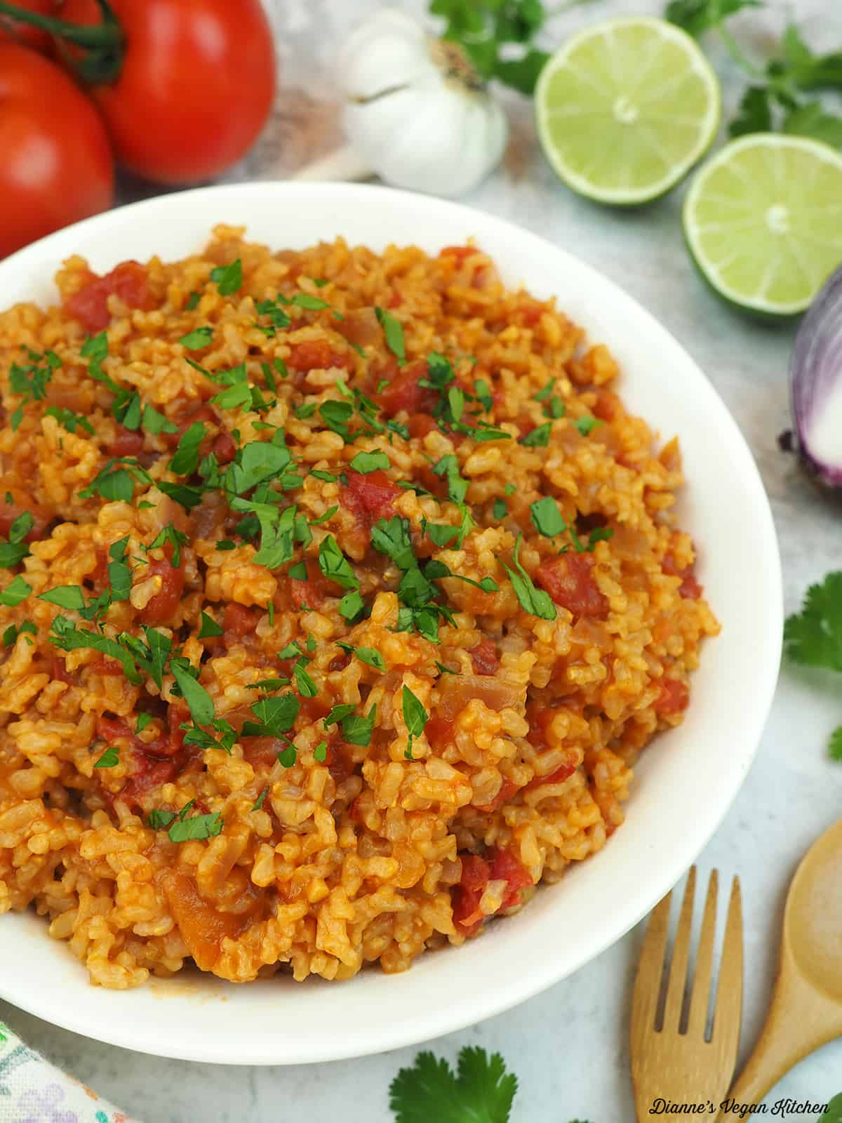 bowl of Spanish rice with tomatoes, limes, garlic, and onion