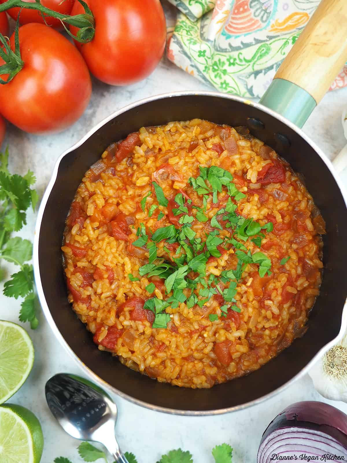 pot of rice overhead, surrounded by tomatoes, limes, and onion