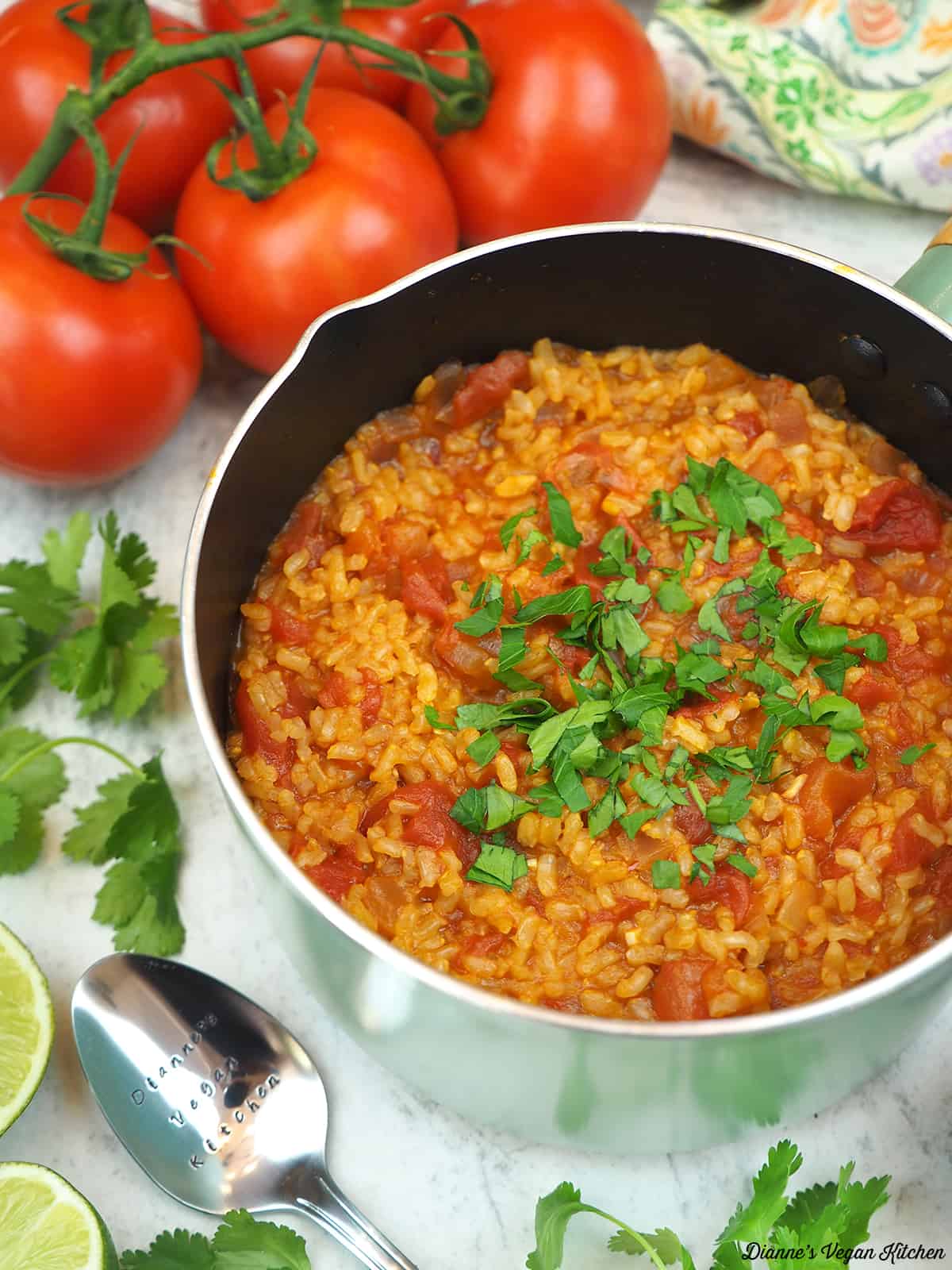 pot of spanish rice with tomatoes and limes