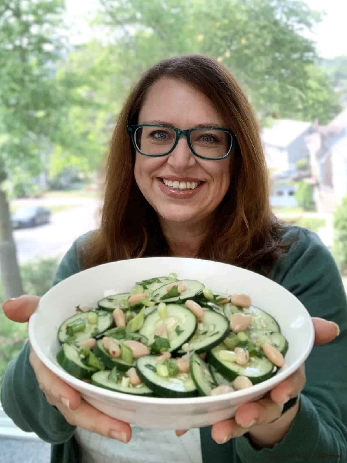 Dianne holding up a bowl of cucumber salad