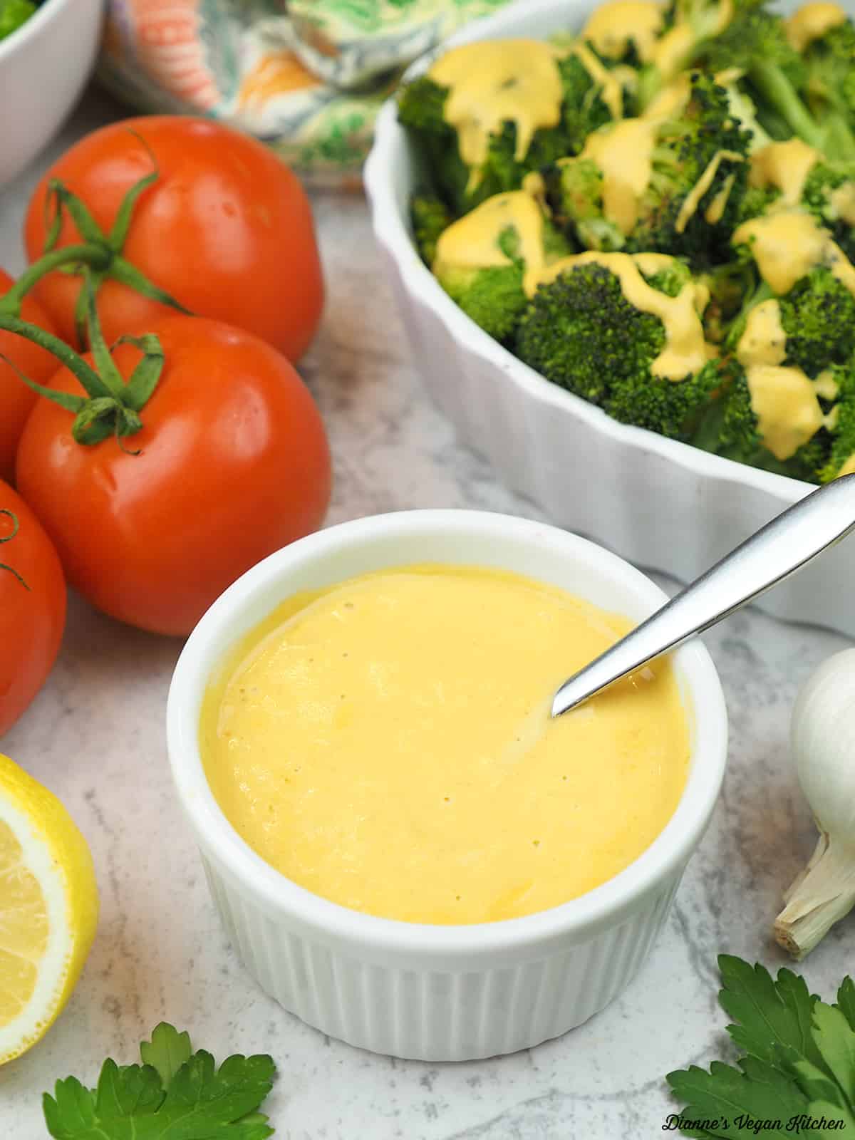 dish of cheese sauce with broccoli in the background
