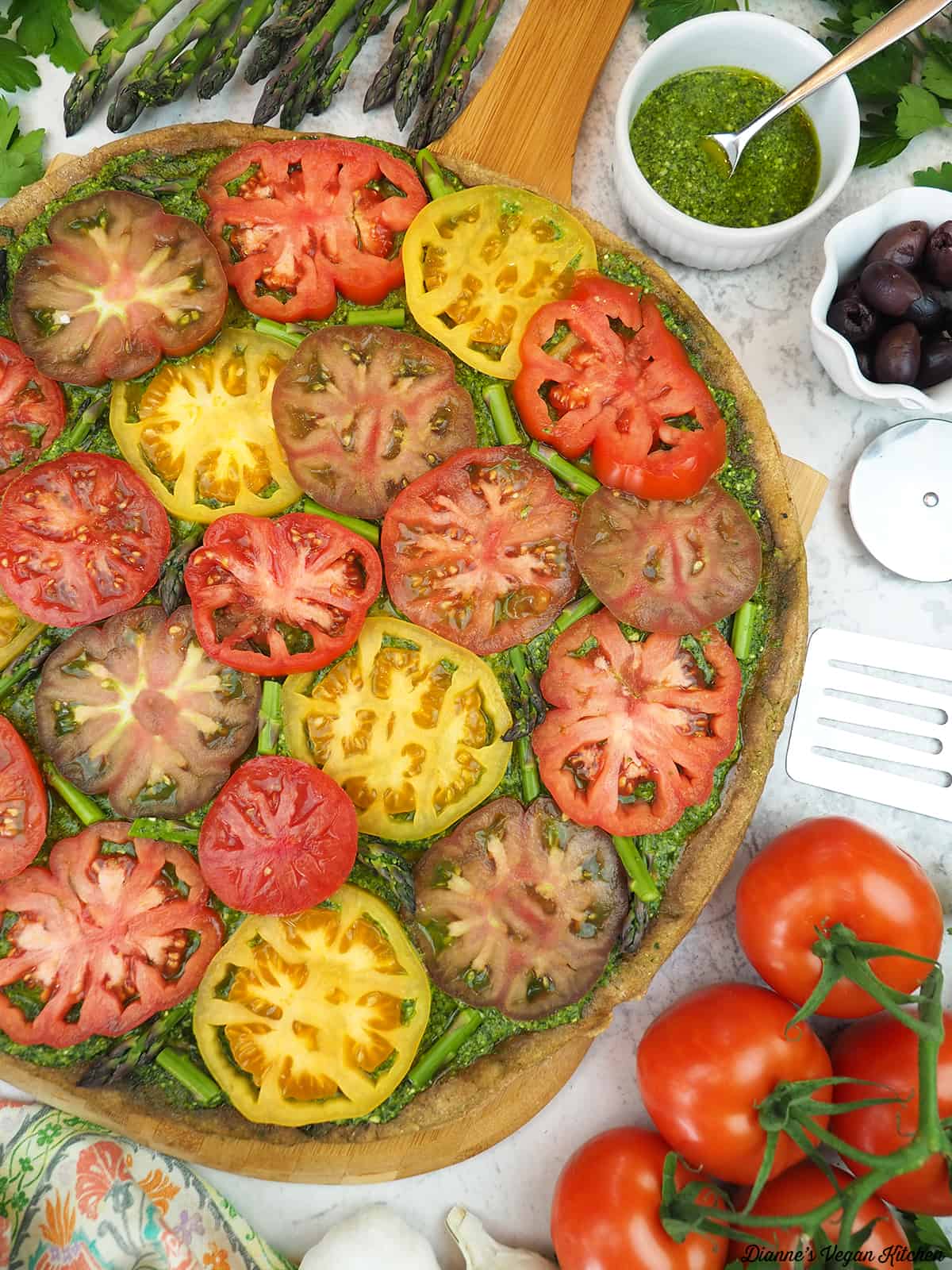 Grilled Pesto Tart with Tomatoes with tomatoes, pesto, olives, garlic, and asparagus