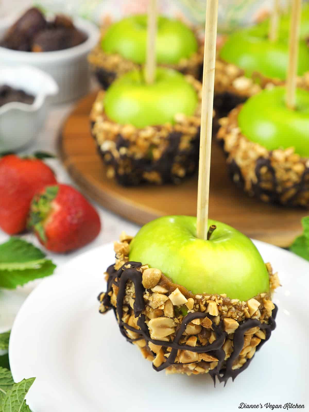 caramel apple on plate with more apples in the background