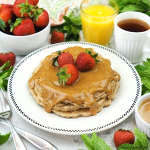 plate of pancakes with strawberries, orange juice, and tea square